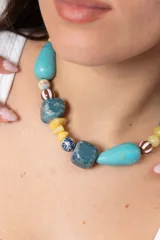 Collar corto con piedras y cuentas en tonos turquesa, azul, amarillo y beige de formas irregulares.