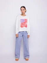 Remera blanca de manga larga con estampa frontal de la frase 'Peace & Love' en letras color lila y diseño floral en rojo.