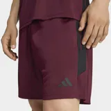 Short de fútbol Adidas Tiro 26 Essentials de color bordó, con bandas laterales negras y logo bordado.