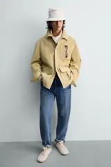 Zapatilla de cordones para hombre, confeccionada en piel con acabado de serraje en color beige. Presenta un diseño de perfil bajo con detalles de pespuntes decorativos y una suela ultrafina.