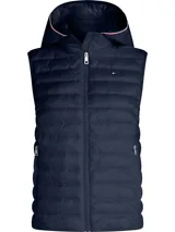 Chaleco azul marino acolchado con capucha, cierre de cremallera frontal y dos bolsillos laterales con cremallera. Tiene el logo de Tommy Hilfiger bordado en el pecho y detalles distintivos de la marca.