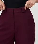 Pantalón de sastrería corte recto, color marrón, con cintura de tiro medio, trabillas largas y bolsillos traseros.