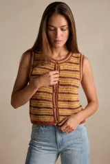 Chaleco de punto sin mangas, con cuello redondo y cierre frontal de botones. Presenta un diseño de rayas horizontales en tonos tierra, mostaza y crema, con una textura tejida distintiva.