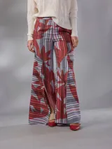 Pantalón de cintura alta y piernas amplias en lino mezcla, con estampado vegetal en tonos bordó, gris y blanco, y tajos asimétricos en las piernas. Cuenta con cierre invisible lateral y bolsillos.