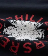 Remera negra de algodón con cuello redondo y manga corta, corte comfort. Presenta un pequeño estampado circular en el pecho con el logo de la banda Red Hot Chili Peppers.