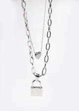 Collar doble plateado con cadena de eslabones gruesos y cadena fina. Incluye dije de corazón y dije de candado.
