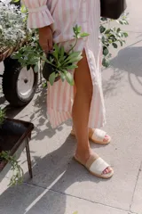 Sandalias planas de cuero marrón con tira ancha sobre el empeine. La plantilla es de cuero con la inscripción "LE".