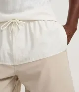 Bermuda de baño de microfibra con diseño bicolor, cintura elástica con cordón ajustable, bolsillos laterales y bolsillo trasero con cierre.
