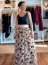 Falda larga de tul en color canela con bordados de flores negras. Presenta una silueta amplia y fluida, ideal para eventos formales.