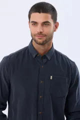 Camisa de manga larga confeccionada en pana fina de algodón, con cuello camisero, cierre frontal de botones y un bolsillo aplicado en el pecho.