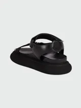 Sandalias negras de goma con tiras ajustables y suela track.