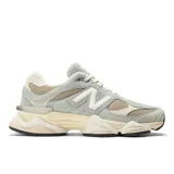 Championes New Balance modelo 9060, de diseño chunky en tonos gris claro, beige y blanco. Confeccionados con parte superior de malla y superposiciones de gamuza, entresuela de doble densidad y el icónico logo "N" en los laterales.