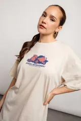 Remera color crema de algodón con estampado de frutas y texto en azul.