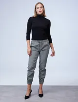 Pantalón jogger con estampado cuadrillé en blanco y negro, con pretina ancha elastizada con frunces, bolsillos laterales y ruedo con elástico fruncido.