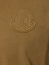 Remera de algodón Moncler color marrón con cuello redondo, manga corta y parche con logo bordado en el pecho.