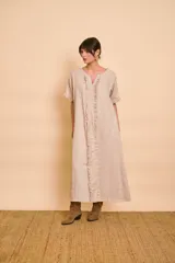 Vestido tipo túnica largo de lino color beige, de manga corta, con detalles de volados en el frente y bolsillos laterales.