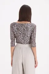 Remera de manga tres cuartos con escote bote, confeccionada en tejido con estampado animal print en tonos marrones y destellos metalizados.