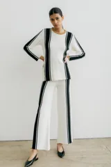 Sweater de punto negro con rayas verticales blancas y cuello redondo color marrón.