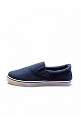 Mocasines tipo slip-on de lona color azul marino con suela blanca de goma y elásticos laterales para facilitar el calce.