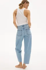 Jean barrel de tiro alto confeccionado en denim de algodón rígido, con diseño curvo y voluminoso en las piernas, largo tobillero y cinco bolsillos. Cuenta con cierre de botones en el frente.