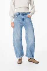 Jean de corte wide leg y tiro medio, con diseño de costuras laterales curvadas que le otorgan una silueta redondeada. Presenta un lavado azul claro con efecto desgastado, cierre frontal con botón y bolsillos laterales.
