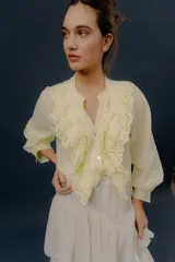 Camisa verde de manga larga, con volados frontales y detalles de puntilla bordada.