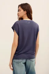 Remera de lino color azul marino, de corte holgado, cuello redondo y mangas cortas con diseño caído.