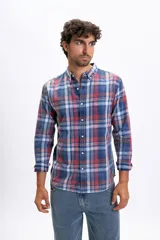 Camisa de manga larga con estampado de cuadros en tonos azules, rojos y blancos, con efecto lavado, cuello abotonado y bolsillo frontal.