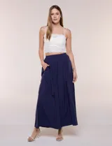 Falda larga de color blanco con pretina elastizada y fruncidos en la cintura, con caída holgada y ligera.