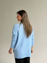 Sweater de punto color celeste, con cuello en V, mangas largas con puños acanalados y detalle de costura vertical central.