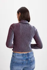 Campera corta de tejido de punto acanalado con diseño de rayas verticales en dos tonos. Presenta cuello alto y cierre frontal completo con borde en color negro.