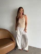 Pantalón de viscosa color beige claro, de corte amplio y pierna ancha, con cintura elástica y bolsillos laterales.