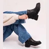 Bota corta de cuero vacuno color negro, con suela de goma tipo track y cierre lateral interno. Diseño de punta redonda y caña media.