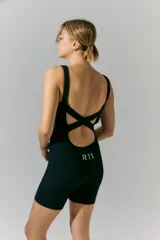 Mono corto negro de tejido de punto sin costuras, con espalda descubierta y tiras cruzadas. Estampa con logo en la espalda.