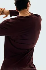 Remera deportiva de manga larga color bordó, con cuello redondo y tejido funcional con textura microperforada.