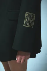Saco sastrero oversize negro con bolsillos delanteros, forro de tafeta a tono y bordado en la tapa del bolsillo.