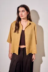 Camisa de lyocell color mostaza, de corte holgado, mangas cortas y cierre frontal con botones.