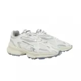 Championes Lacoste modelo L003 2K24, de diseño deportivo y urbano. Presentan una combinación de malla técnica y superposiciones sintéticas en color blanco con detalles plateados. Cuentan con una suela robusta de goma en tono crema con relieve dentado para mayor tracción.