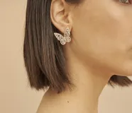 Aros dorados en forma de mariposa, con diseño calado y engastados con circonias brillantes.