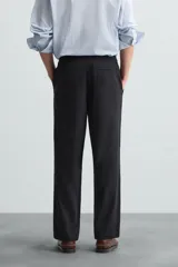 Pantalón de corte relajado color beige confeccionado en tejido de mezcla de algodón y lino. Posee cintura elástica ajustable con cordón, bolsillos frontales y bolsillos traseros de vivo.