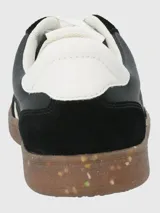 Zapatillas urbanas de diseño deportivo, color negro con detalles en blanco y suela de goma color caramelo con efecto moteado.