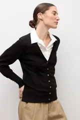 Cardigan negro con escote en V, manga larga y cierre frontal con botones pequeños. Presenta puños acanalados con detalle de botones decorativos.