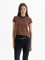 Remera de punto liso elastizada color marrón, con escote redondo a la base, mangas cortas y logo JCH bordado en la espalda. Su fit es al cuerpo.