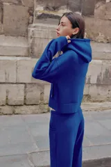 Pantalón flare de tiro medio, color azul, confeccionado en tejido de punto elástico. Cuenta con cintura elástica ajustable con cordón, bolsillos delanteros y corte amplio en las piernas.