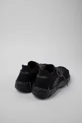 Championes negros con cordones gruesos en blanco y negro, suela gruesa con textura y puntera reforzada.