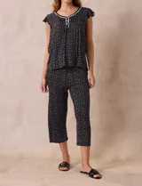 Conjunto de pijama marca René Rofé, compuesto por una remera de escote en V con botones y un pantalón capri con cintura elastizada, ambos en tejido soft estampado con motivos florales en tonos celeste y blanco.