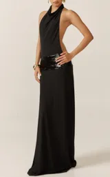 Vestido largo negro de fiesta, con escote halter drapeado, espalda descubierta y faja de lentejuelas negras en la cintura.