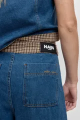 Pantalón de jean azul de corte ancho y tiro alto, con costuras verticales frontales que estilizan la silueta y diseño de pierna recta.