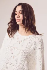 Sweater de tejido de punto calado color marrón, con diseño oversize, cuello redondo y mangas tres cuartos.