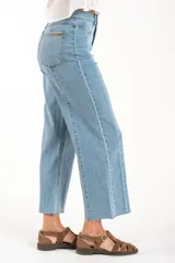 Jean de corte recto y tiro medio, confeccionado en denim de algodón con un toque de elastano. Presenta costuras verticales decorativas a lo largo de las piernas y un ruedo deshilachado.